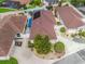 An aerial shot shows a well-maintained home with a dark roof, tidy landscaping, and an adjacent pool in the neighborhood at 632 Delgado Ave, The Villages, FL 32159