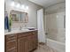 Well-lit bathroom includes a marble-top vanity and shower-tub combination at 632 Delgado Ave, The Villages, FL 32159