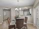 Dining area featuring a glass-top table, wicker chairs, and elegant chandelier lighting at 632 Delgado Ave, The Villages, FL 32159