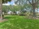 Expansive community green space with mature trees and lush lawn, creating a serene and inviting atmosphere at 632 Delgado Ave, The Villages, FL 32159