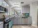 Modern kitchen featuring stainless steel appliances, gray cabinetry, and granite countertops at 632 Delgado Ave, The Villages, FL 32159
