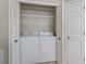 Convenient laundry closet featuring a washer, dryer, and ample shelving at 632 Delgado Ave, The Villages, FL 32159