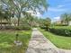 Picturesque community path surrounded by mature trees and manicured landscaping, perfect for a leisurely stroll at 632 Delgado Ave, The Villages, FL 32159