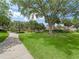 Meandering path through a lush green space with mature trees and well-manicured landscaping at 632 Delgado Ave, The Villages, FL 32159