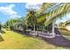 Scenic backyard with a stone patio, lush trees, and a screened-in lanai at 857 Enisgrove Way, The Villages, FL 32163