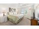 Bright bedroom features a tray ceiling, side tables, palm tree bedding and a large window at 857 Enisgrove Way, The Villages, FL 32163