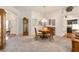 Cozy dining area with a round table, carpeted floors, and a glimpse into the kitchen at 857 Enisgrove Way, The Villages, FL 32163
