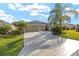 Wide driveway leading to a two-car garage, framed by a well-manicured lawn and landscaping at 857 Enisgrove Way, The Villages, FL 32163