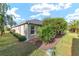 Exterior angle of home with a well-manicured lawn and mature greenery at 857 Enisgrove Way, The Villages, FL 32163
