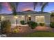 Beautiful single story home featuring a well-maintained lawn and a two-car garage at dusk at 857 Enisgrove Way, The Villages, FL 32163