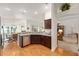 Open-concept kitchen with stainless steel appliances, dark wood cabinets, and a breakfast bar overlooking the living area at 857 Enisgrove Way, The Villages, FL 32163