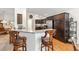 Kitchen breakfast bar with seating, transitioning into the dining and kitchen area with stainless appliances at 857 Enisgrove Way, The Villages, FL 32163