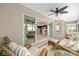 Covered patio features wicker furniture with access to a sunroom and views of the eat-in kitchen at 857 Enisgrove Way, The Villages, FL 32163