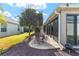 Back patio with a table and chairs that is accessible from the screened-in porch at 857 Enisgrove Way, The Villages, FL 32163