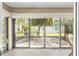 Enclosed patio featuring an outdoor dining set, landscaping and pavers at 857 Enisgrove Way, The Villages, FL 32163