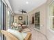 Covered sunroom features wicker furniture, ceiling fan and sliding glass doors leading to the living room at 857 Enisgrove Way, The Villages, FL 32163