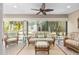 Bright sunroom features wicker furniture, ceiling fan and views of the green yard at 857 Enisgrove Way, The Villages, FL 32163