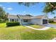 Well-maintained home with a covered porch, manicured lawn, and a screened-in garage at 917 Camino Del Rey Dr, The Villages, FL 32159