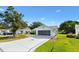 Charming home featuring a screened garage, well-maintained lawn, and a delightful palm tree driveway design at 917 Camino Del Rey Dr, The Villages, FL 32159