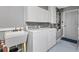 Functional laundry room with washer, dryer, sink, and plenty of storage at 917 Camino Del Rey Dr, The Villages, FL 32159