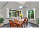 Bright dining room featuring a wood table, six chairs, large windows, and charming garden views at 9642 Bear Lake Rd, Apopka, FL 32703