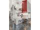 Modern kitchen with marble counters, breakfast bar, stainless appliances, and unique red accent wall with loft view at 9642 Bear Lake Rd, Apopka, FL 32703