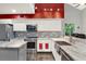 Spacious kitchen featuring stainless steel appliances, white cabinets, marble countertops, and a stainless farm sink at 9642 Bear Lake Rd, Apopka, FL 32703
