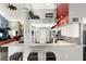Modern kitchen with marble counters, breakfast bar, stainless appliances, and unique red accent wall with loft view at 9642 Bear Lake Rd, Apopka, FL 32703