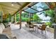 Spacious outdoor living area with a covered patio, dining area, and tranquil view of the backyard and waterfront at 9642 Bear Lake Rd, Apopka, FL 32703
