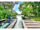 Tranquil pool with a lake view surrounded by lush greenery and blue Adirondack chairs at 9642 Bear Lake Rd, Apopka, FL 32703
