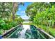 Infinity edge pool in lush backyard overlooking serene lake at 9642 Bear Lake Rd, Apopka, FL 32703