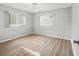 Bright bedroom with two large windows, ceiling fan, and vinyl wood flooring at 9757 Se 175Th Pl, Summerfield, FL 34491
