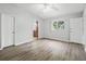 Bedroom featuring wood-look flooring, neutral walls, ceiling fan, and access to the ensuite bathroom at 9757 Se 175Th Pl, Summerfield, FL 34491