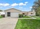 Charming single-story home featuring a well-manicured lawn, attached garage, and inviting curb appeal with a tidy walkway at 9757 Se 175Th Pl, Summerfield, FL 34491