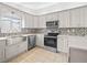 Bright kitchen featuring white cabinetry, stainless steel appliances, and stylish backsplash at 9757 Se 175Th Pl, Summerfield, FL 34491