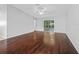 Bright, open living room with dark wood flooring and a sliding glass door to an enclosed patio at 9757 Se 175Th Pl, Summerfield, FL 34491