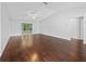 Spacious living room featuring sleek, dark hardwood floors and a sliding glass door leading to the screened lanai at 9757 Se 175Th Pl, Summerfield, FL 34491