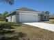 Charming single-story home with a two-car garage, manicured lawn, and a paved driveway at 15010 Sw 29Th Ave Road, Ocala, FL 34473