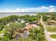 Aerial view of a lakeside property with mature trees and houses and a road leading to a lake at 1001 N Lakeshore Blvd, Howey In The Hills, FL 34737