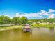 Beautiful lake view featuring a wooden dock with a gazebo, surrounded by lush green parkland at 1001 N Lakeshore Blvd, Howey In The Hills, FL 34737