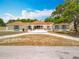 Charming single story home with a sprawling front yard and inviting porch, complete with cozy seating at 1001 N Lakeshore Blvd, Howey In The Hills, FL 34737