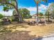 Spacious front yard featuring outdoor furniture, a picnic table, grill, and a charming gazebo under mature trees at 1001 N Lakeshore Blvd, Howey In The Hills, FL 34737