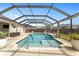 Inviting screened-in pool featuring a sun shelf, safety railing, and manicured landscaping for serene enjoyment at 11362 Zimmerman Path, Oxford, FL 34484