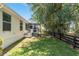 Backyard view of home with porch, green lawn and black fence at 1212 Chaparral Dr, Lady Lake, FL 32159