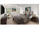 Cozy bedroom with neutral tones, fan, and warm accents from the bedside lamps and tasteful artwork at 1212 Chaparral Dr, Lady Lake, FL 32159