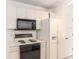 Well-lit kitchen with white appliances, black oven range, and tile flooring at 1212 Chaparral Dr, Lady Lake, FL 32159