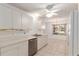 Bright kitchen featuring white cabinets, stainless steel dishwasher, and tile flooring at 1212 Chaparral Dr, Lady Lake, FL 32159