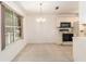 Bright kitchen and dining area featuring tile floors, white cabinets, and a chandelier at 1212 Chaparral Dr, Lady Lake, FL 32159