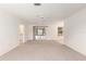 Spacious living room with neutral carpet, white walls, and access to other rooms in the home at 1212 Chaparral Dr, Lady Lake, FL 32159