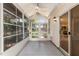 A view of the screened in porch with neutral walls and access to the kitchen at 1212 Chaparral Dr, Lady Lake, FL 32159
